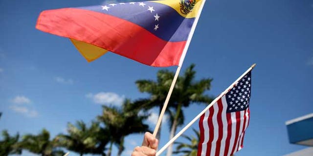 MIAMI, FL - MARCH 01: A protester holds a Venezuelan and American flag as she and other Venezuelans and their supporters show their support for the anti-government protests in Venezuela on March 1, 2014 in Miami, Florida. (Photo by Joe Raedle/Getty Images)