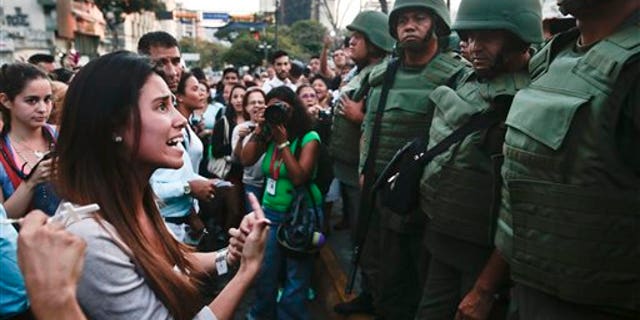 An anti-government protester argues with Bolivarian National Guards in Plaza Altamira in Caracas, Venezuela, Monday, March 17, 2014. Security forces on Monday took control of a Caracas plaza that has been at the heart of anti-government protests that have shaken Venezuela for a month. (AP Photo/Esteban Felix)