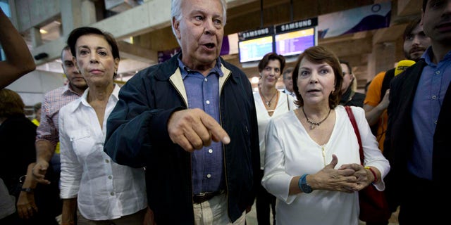 Spain's former president Felipe Gonzalez walks with Antonieta Mendoza, mother of jailed opposition leader Leopoldo Lopez, left, and Mitzy Capriles, wife of imprisoned Caracas Mayor Antoino Ledezma upon his arrival at Maiquetia International airport in la Guaira, Venezuela, Sunday, June 7, 2015.
