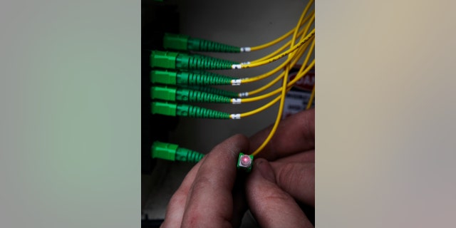 FILE - In this March 13, 2009, file photo, Tyson Hoffman, a Verizon service technician, checks a cable as he connects it to the Verizon FiOS fiber network in Rockville, Md. Verizon is boosting the upload speeds of nearly all its FiOS connections to match the download speeds, vastly shortening the time it takes for subscribers to upload videos and back up their files online, the company announced Monday, July 21, 2014. (AP Photo/Alex Brandon, File)