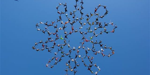 July 31: In this photo provided by Jason Peters, members of an international team of skydivers join hands flying head-down to build their world record skydiving formation over Ottawa, Ill.