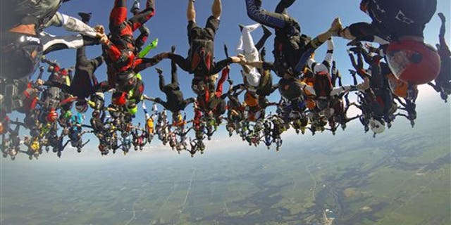 July 31: In this photo provided by Mickey Nuttall, members of an international team of skydivers join hands flying head-down to build their world record skydiving formation over Ottawa, Ill.