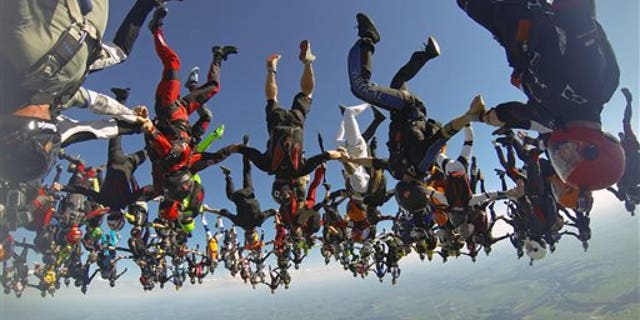 July 31: In this photo provided by Mickey Nuttall, members of an international team of skydivers join hands flying head-down to build their world record skydiving formation over Ottawa, Ill.