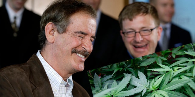 Former Mexican President Vicente Fox, left, speaks as Jamen Shively, CEO of Diego Pellicer, looks on during a news conference Thursday, May 30, 2013, in Seattle. (AP Photo/Elaine Thompson)