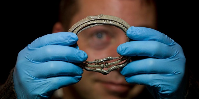 Dec. 14, 2011: Metal detectorist Darren Webster poses with a Viking arm-ring he discovered, estimated to date back to the late ninth or early tenth century, at the British Museum in London. The arm-ring is part of the Silverdale Viking Hoard discovered by Webster in September 2011 in the Silverdale area of North Lancashire, England. It comprises 201 silver objects including arm-rings, coins, finger-rings, ingots, brooch fragments and a fine wire braid.