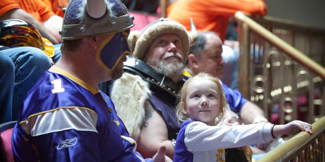 May 8, 2012: Minnesota Vikings fan Hannah Walsh, 5, sits between "Skolt," left, also known as Scott Asplund, and Greg Hanson, who goes by Sir Odin, as the state Senate discussed the Vikings stadium bill in St. Paul, Minn.