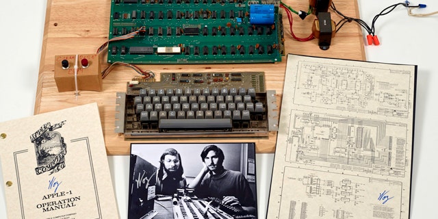 This undated photo provided by Christie’s Auction House shows an “Apple 1” prototype computer, built in 1976, accompanied by an operation manual and schematic as well as a photo of its inventors, Steve Wozniak, left, and Steve Jobs.