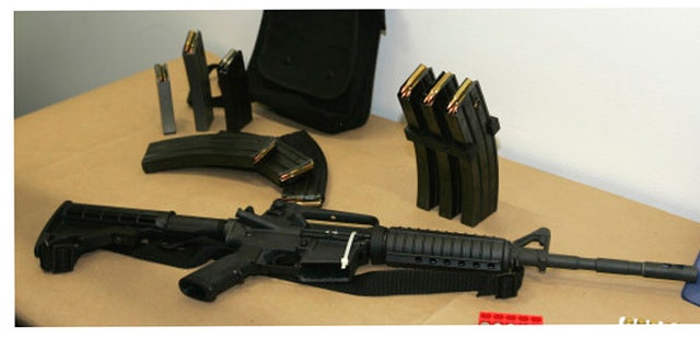 FILE - This March 27, 2006 file photo, shows a Bushmaster AR-15 semi-automatic rifle and ammunition on display at the Seattle Police headquarters in Seattle. The maker of the Bushmaster rapid-fire weapon used to kill schoolchildren in Connecticut on Friday, Dec. 14, 2012, was put up for sale on Tuesday, Dec. 18, 2012, as investors soured on the gun business. (AP Photo/Ted S. Warren, File)
