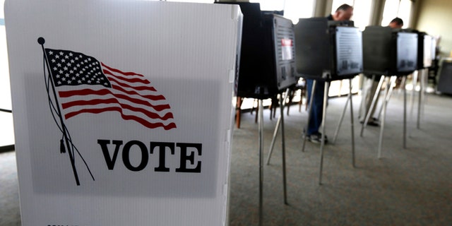 FILE - In this March 18, 2014 file photo, voters cast their ballots in the Illinois primary in Hinsdale, Ill. Republicans have gained ground on Democrats' strength in registering voters in three battleground states _ and kept their razor-thin advantage in Iowa, offering some hope for Donald Trump and raising the stakes over ballot access in the final weeks before Election Day. (AP Photo/M. Spencer Green, File)