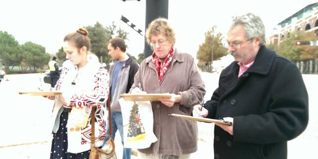 Voters in Arlington are seen signing the anti-camera petition started by Canon and Bussey.