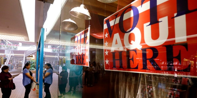Voters wait in line at a polling place located inside a shopping mall on Election Day, 2012, in Austin, Texas.