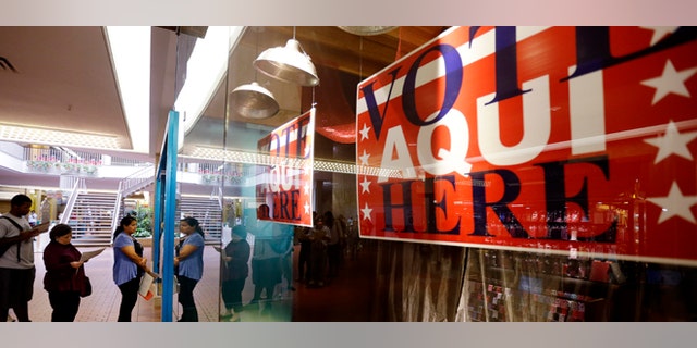 Voters wait in line at a polling place located inside a shopping mall on Election Day, 2012, in Austin, Texas.
