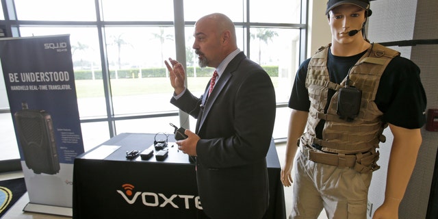 John Hall, president and CEO of Voxtec International, demonstrates his company's real-time translation system, during a media opportunity at the U.S. Southern Command headquarters.