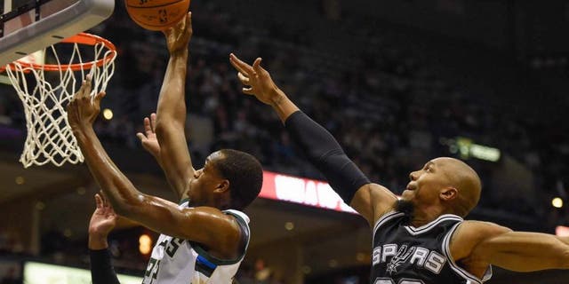 Monday, Jan. 4: Milwaukee Bucks guard Khris Middleton (left) takes a shot against San Antonio Spurs forward David West in the first quarter at BMO Harris Bradley Center in Milwaukee, Wis.