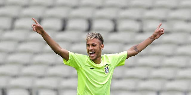 FILE - This June 16, 2014 file photo shows Brazil's Neymar smiling as he holds out his arms during a training session at the Arena Castelao in Fortaleza, Brazil. Through one week of the World Cup, Facebook has already seen more people having more interactions about the tournament on the social media site than it had for the Sochi Olympics, Super Bowl and Academy Awards combined. A photo posted by Pitbull, who performed at the opening ceremonies, has received more than 1.2 million interactions, as has a photo posted by Brazilian soccer star Neymar, Facebook said. (AP Photo/Andre Penner)