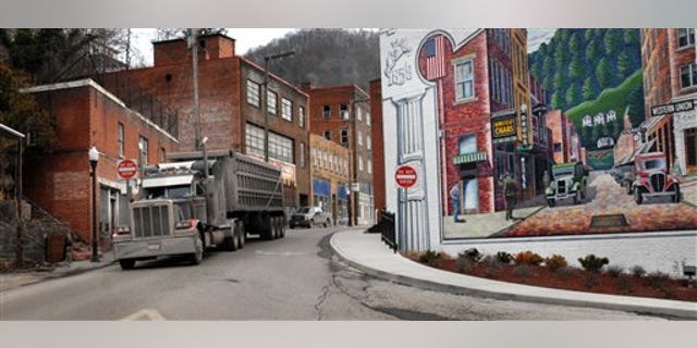 A coal truck drives out of downtown Welch, W.Va., Wednesday, Feb. 9, 2011. Coal brought a large population to the McDowell County in the 1940's. Now the population is shrinking and the county suffers from unemployment and poverty. Now, here as in one-fourth of all U.S. counties, West Virginia's graying residents are slowly dying off. Hit by an aging population and a poor economy, a near-record level of U.S. counties is experiencing more deaths than births in their communities, a phenomenon demographers call "natural decrease." (AP Photo/Jon C. Hancock)