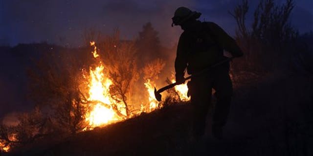 Gold Bar Fire Lt. Scott Coulson investigates brush fires in the hills outside of Omak, Wash., on Friday, Aug. 21, 2015, as wildfires continue to burn throughout north-central Washington. (Genna Martin/The Herald via AP)