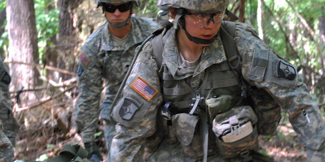 FILE - In a May 9, 2012 file photo, Capt. Sara Rodriguez, 26, of the 101st Airborne Division, carries a litter of sandbags during the Expert Field Medical Badge training at Fort Campbell, Ky. The Pentagon is lifting its ban on women serving in combat, opening hundreds of thousands of front-line positions and potentially elite commando jobs after generations of limits on their service, defense officials said Wednesday, Jan. 23, 2013. (AP Photo/Kristin M. Hall, File)