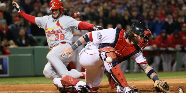 Oct. 24, 2013: Boston Red Sox catcher Jarrod Saltalamacchia is unable to handle the throw from left fielder Jonny Gomes as St. Louis Cardinals pinch runner Pete Kozma scores on a sacrifice fly by Matt Carpenter in the seventh inning during Game 2 of the World Series between the St. Louis Cardinals and the Boston Red Sox at Fenway Park in Boston. Pitcher Craig Breslow backing up the play threw wildly to third for an error, allowing Jon Jay to also score on the play. (AP/St. Louis Post-Dispatch, Chris Lee)
