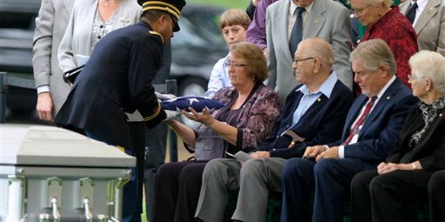 September 21: Bonnie Williams, daughter of Tech Sgt. Robert L. Christopherson, receives a flag from Army Chaplain John Gabriel during a during a burial ceremony for nine WW II Army Airmen at Arlington National Cemetery in Arlington, Va.