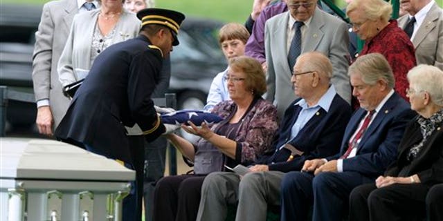 September 21: Bonnie Williams, daughter of Tech Sgt. Robert L. Christopherson, receives a flag from Army Chaplain John Gabriel during a during a burial ceremony for nine WW II Army Airmen at Arlington National Cemetery in Arlington, Va.
