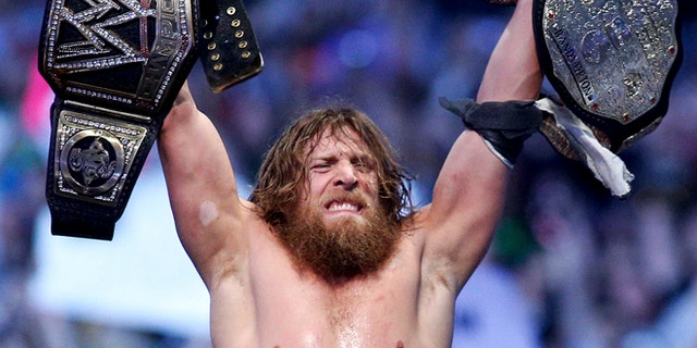 April 2014: Daniel Bryan celebrating after winning the main event during Wrestlemania XXX at the Mercedes-Benz Super Dome in New Orleans. Police say the former WWE champion, Bryan chased two burglary suspects he saw exiting his Phoenix home this week and subdued one until officers arrived.