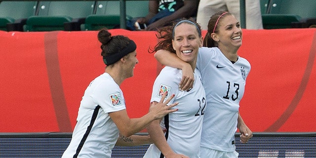 United States' Ali Krieger (11), Lauren Holiday (12) and Alex Morgan (13) celebrate a goal against Colombia during second half FIFA Women's World Cup round of 16 soccer action in Edmonton, Alberta, Canada, Monday, June 22, 2015. (Jason Franson/The Canadian Press via AP) MANDATORY CREDIT