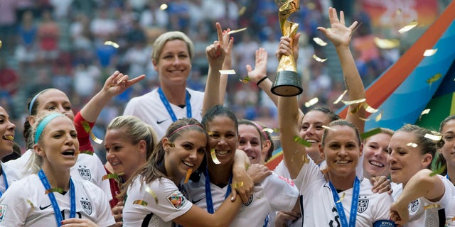 The United States Women's National Team celebrates with the trophy after they defeated Japan 5-2 in the FIFA Women's World Cup soccer championship in Vancouver, British Columbia, Canada, Sunday, July 5, 2015. (Darryl Dyck/The Canadian Press via AP) MANDATORY CREDIT