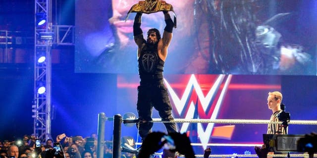 In this photograph taken on January 15, 2016, wrestler Roman Reigns holds up the Championship Belt during the World Wrestling Entertainment (WWE) Live India Tour in New Delhi. Enthusiastic fans flocked to the event as WWE returned to the country after an interval of 13 years. AFP PHOTO/ CHANDAN KHANNA / AFP / Chandan Khanna (Photo credit should read CHANDAN KHANNA/AFP/Getty Images)