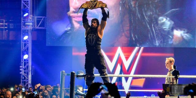 In this photograph taken on January 15, 2016, wrestler Roman Reigns holds up the Championship Belt during the World Wrestling Entertainment (WWE) Live India Tour in New Delhi. Enthusiastic fans flocked to the event as WWE returned to the country after an interval of 13 years. AFP PHOTO/ CHANDAN KHANNA / AFP / Chandan Khanna (Photo credit should read CHANDAN KHANNA/AFP/Getty Images)