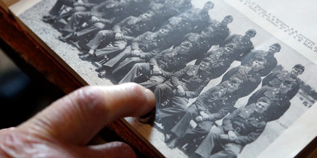 May 8, 2014: World War II veteran Arthur Robinson of Saratoga Springs, N.Y., points to himself in a 1940 photograph with his unit at the New York State Military Museum in Saratoga Springs. (AP)