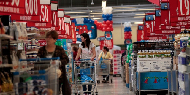 In this Sept. 1, 2015, photo, women shop in a Wal-Mart Lider hypermarket in Santiago, Chile. Soon after Wal-Mart's acquisition of the countrys largest supermarket chain Distribucion y Servicio, S.A., Wal-Mart made red the signature color for price signs for its Lider supercenters because Chileans associate red with good deals. (AP Photo/Luis Hidalgo)