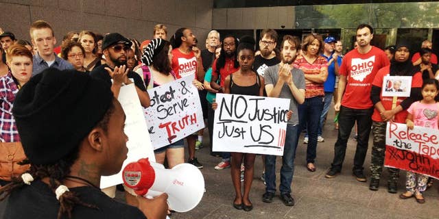 In this photo taken on Monday, Aug. 5, 2014, members of the Ohio Student Association gathered outside Ohio Attorney General Mike DeWine's office in Columbus, Ohio, to call for the release of in-store video in the fatal police shooting of a man at a Dayton-area Wal-Mart. Organizers tell the Dayton Daily News they want to see what happened on Aug. 5 when 21-year-old John Crawford III was fatally shot by police. Officers say he refused to drop an air rifle inside a Wal-Mart store in Beavercreek.  (AP Photo/The Dayton Daily News, Jim Otte)  LOCAL PRINT OUT; LOCAL TELEVISION OUT; WKEF-TV OUT; WRGT-TV OUT; WDTN-TV OUT