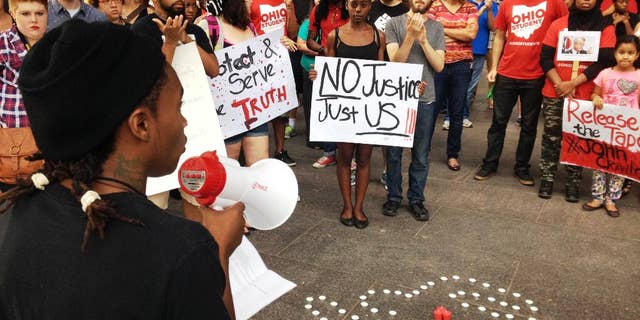 In this photo taken on Monday, Aug. 5, 2014, members of the Ohio Student Association gathered outside Ohio Attorney General Mike DeWine's office in Columbus, Ohio, to call for the release of in-store video in the fatal police shooting of a man at a Dayton-area Wal-Mart. Organizers tell the Dayton Daily News they want to see what happened on Aug. 5 when 21-year-old John Crawford III was fatally shot by police. Officers say he refused to drop an air rifle inside a Wal-Mart store in Beavercreek. (AP Photo/The Dayton Daily News, Jim Otte) LOCAL PRINT OUT; LOCAL TELEVISION OUT; WKEF-TV OUT; WRGT-TV OUT; WDTN-TV OUT