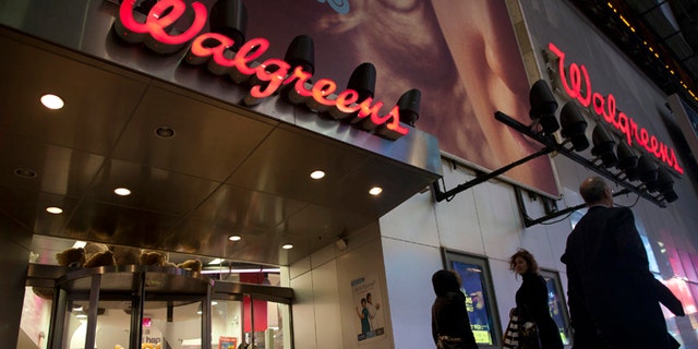 Shoppers walk by a Walgreens in New York.