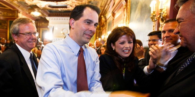 June 6, 2012: Wisconsin Gov. Scott Walker, second from left, and Lt. Gov. Rebecca Kleefisch are greeted by the governor's cabinet and staff at the Wisconsin State Capitol in Madison.