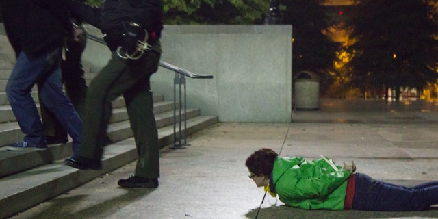 Oct. 28, 2011: An arrested woman watches from the ground of the Legislative Plaza in Nashville, Tenn.