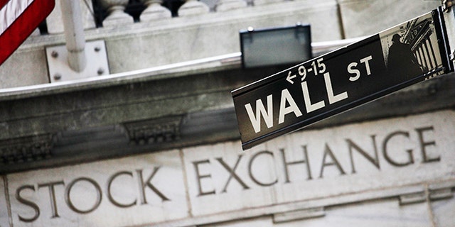 FILE - This July 16, 2013, file photo, shows a Wall Street street sign outside the New York Stock Exchange. U.S. stocks edged mostly lower in midday trading Thursday, Nov. 19, 2015, as traders weighed a mix of company earnings news. Health care stocks were among the biggest decliners after UnitedHealth Group cut its earnings forecast. Payments company Square soared in its market debut. (AP Photo/Mark Lennihan, File)