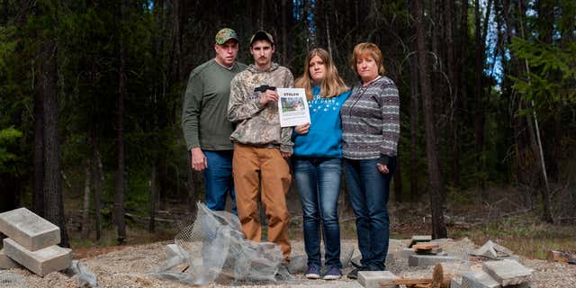 April 8, 2015: Moose Hempel, left, stands with his children, Tyler and Kayla and wife Chris, at the site where their cabin used to stand.