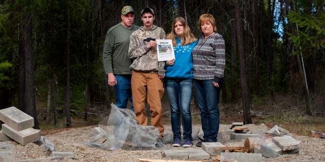 April 8, 2015: Moose Hempel, left, stands with his children, Tyler and Kayla and wife Chris, at the site where their cabin used to stand.