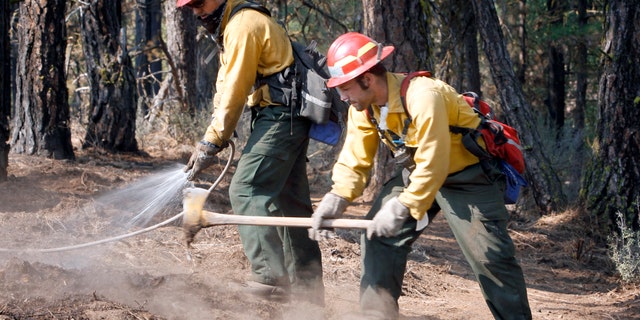 September 10: Alex George, left, and Kevin Weed of Glacier Peak Wildfire, Inc., extinguish hot spots along a fire line near Box Canyon Road on the eastern boundary of the Monastery Complex Fire in Yakima, Washington.