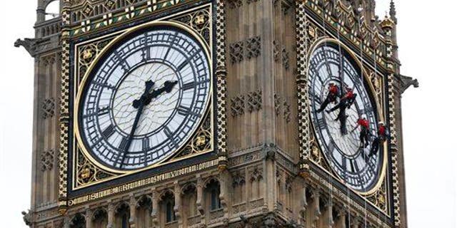 Workers clean the face of Big Ben in London.