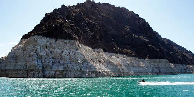 FILE - In this July 17, 2014 file photo, recreational boaters ride by a bathtub ring that delineates the high water mark at Lake Mead in the Lake Mead National Recreation Area in Nevada. Water managers in Las Vegas and the Los Angeles area have reached a deal to draw enough water to serve some 300,000 homes from the Lake Mead reservoir on the Colorado River and sell it to California. (AP Photo/John Locher,File)
