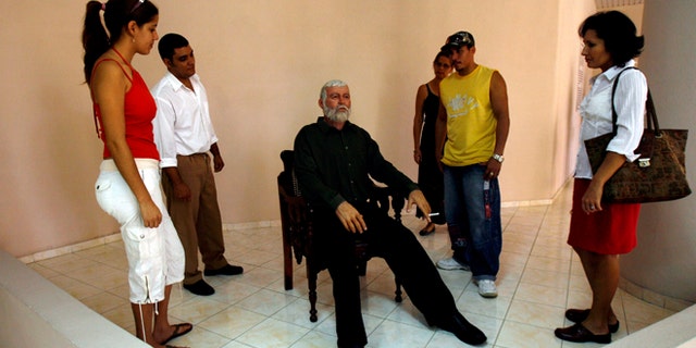 FILE - In this Feb. 2, 2010 file photo, visitors look at a wax figure of U.S. writer Ernest Hemingway at an exhibition in the wax museum at Bayamo, Cuba. Hemingway lived in Cuba on and off for years and worked on some of his most famous books there, including For Whom the Bell Tolls and The Old Man and the Sea. (AP Photo/Ismael Francisco, Prensa Latina, File)