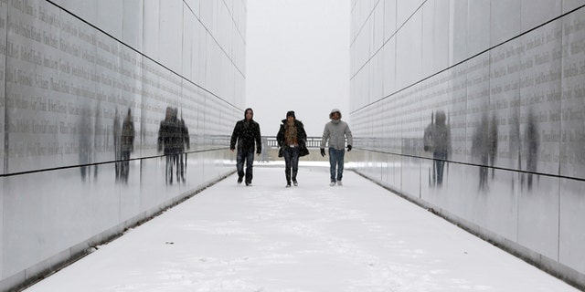 FILE - In this Tuesday, Jan. 21, 2014 file photo, tourists walk through the snow-covered Empty Sky Memorial at Liberty State Park in Jersey City, N.J. Researchers who analyzed local climate trends and hospital records on millions of Americans say there may be a link between weather and the risk for stroke. Cold weather, high humidity and big daily temperature swings brought more stroke hospitalizations. The study by researchers from Yale, Harvard and Duke universities was discussed Wednesday, Feb. 12, 2014 at a stroke conference in San Diego. (AP Photo/Julio Cortez)