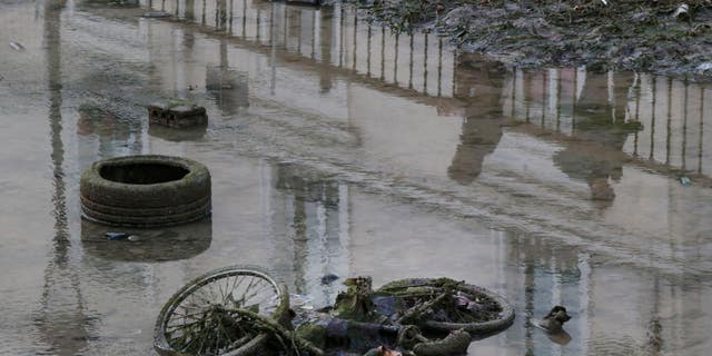 A bicycle and a tire are seen on the ground of the Canal Saint-Martin as the canal is drained for maintenance in Paris on Wednesday.