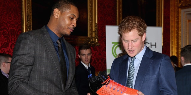 Britain's  Prince Harry, right,  is presented with a basketball shirt and size 15 basketball shoe by NBA All-Star Carmelo Anthony, during a Coach Core Graduation event at St James's Palace, in London, Wednesday, Jan. 14, 2015. The Coach Core model, a year's apprenticeship, aspires to produce well qualified sports coaches to work in the community. (AP Photo/ Chris Jackson, Pool)
