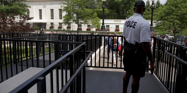 June 9, 2015: A member of the Secret Service Police looks toward the West Wing of the White House in Washington during an evacuation of the media area of the White House because of a bomb threat. (AP Photo/Carolyn Kaster)