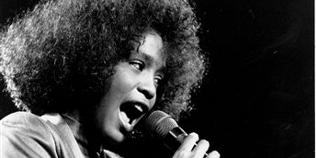 In this May 10, 1986, file photo, American singer Whitney Houston belts out a song during her segment of a benefit concert at Boston Garden. Houston died Saturday, Feb. 11, 2012, she was 48. (AP Photo/Elise Amendola)