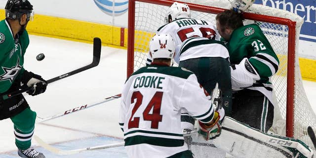 Minnesota Wild left wing Erik Haula (56) collides with Dallas Stars goalie Kari Lehtonen (32), who loses his helmet during the third period an NHL hockey game in Dallas Saturday, March 8, 2014. The Stars won 4-3. (AP Photo/Richard W. Rodriguez)